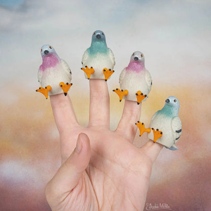 Hand wearing five rubber finger puppet pigeons, one on each finger