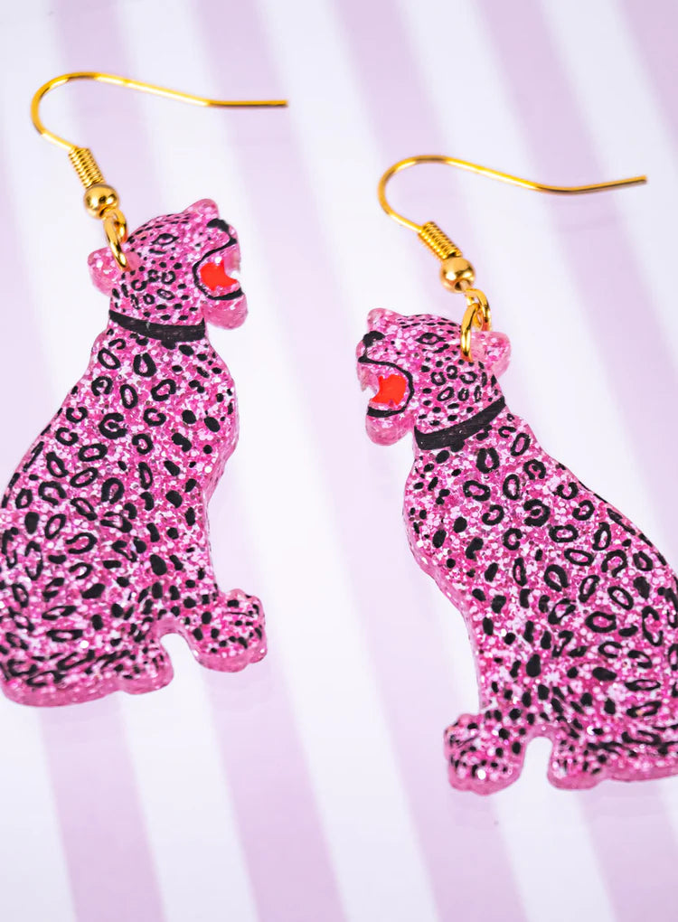 Pink glitter leopard earrings on a striped background