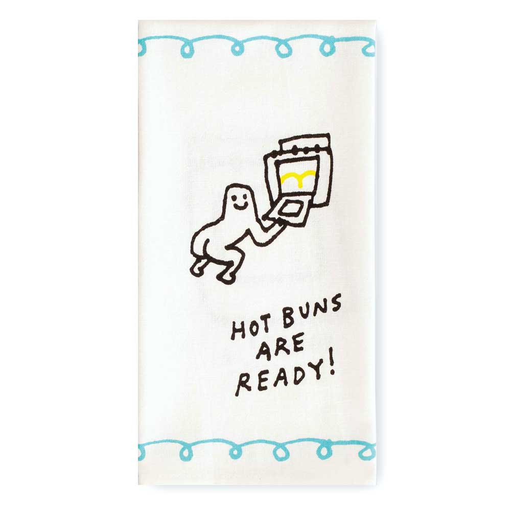 Hot Buns tea towel, folded: a cartoon character carrying a tray of buns with the words 'Hot buns are ready!'
