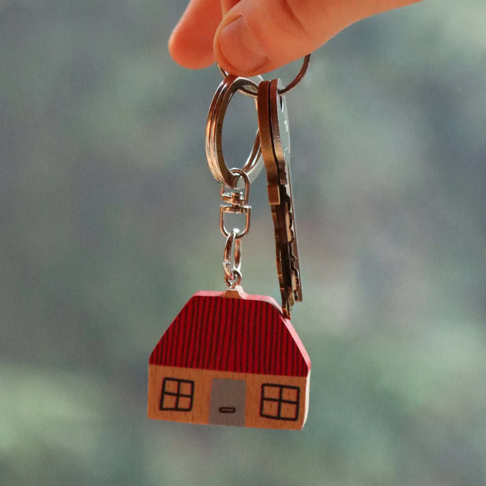 Hand holding up the wooden house keyring