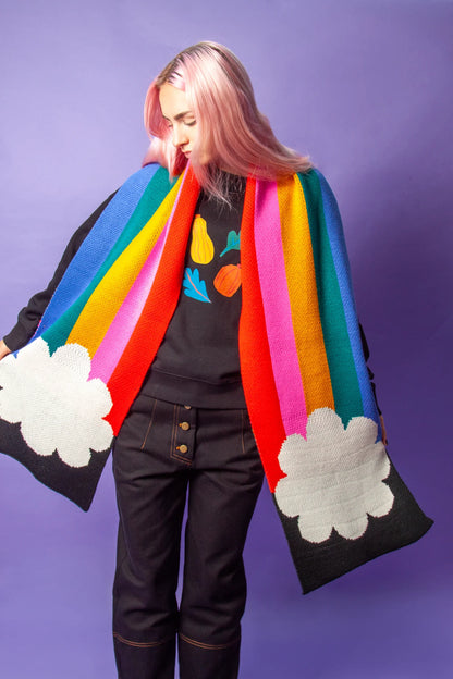 Model holding the rainbow scarf open against a purple background