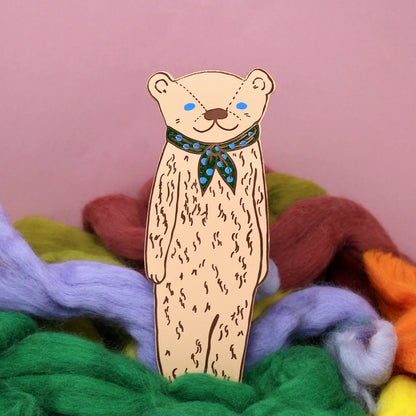 Ark peach bear bookmark with a neckerchief among coloured wool