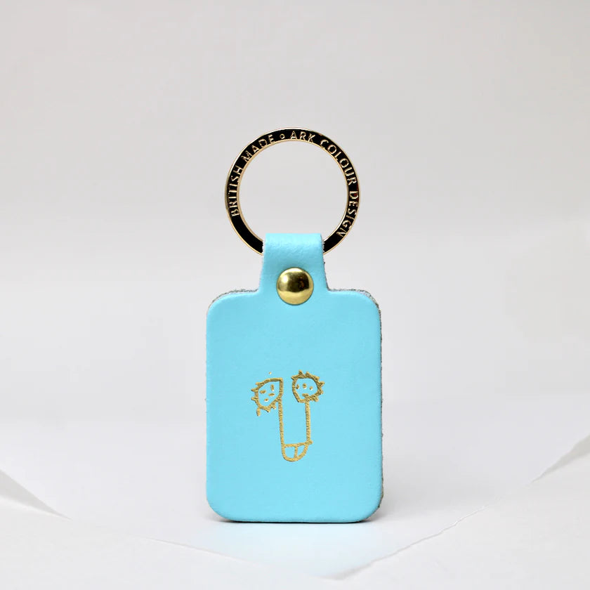 Turquoise leather key fob with a gold cartoon penis