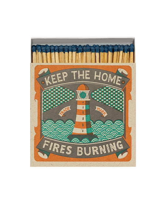 Keep the Home Fires Burning matchbox: a red and white lighthouse on teal waves, opened to show the matches