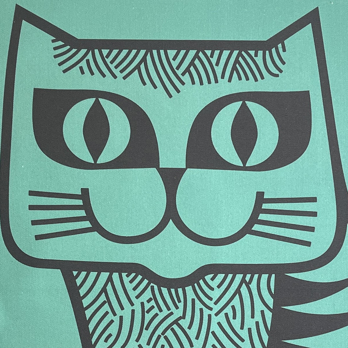 Close-up of the cat's face on the teal tea towel