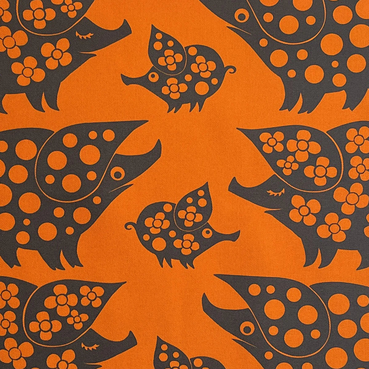Close-up of the orange piggy family tea towel