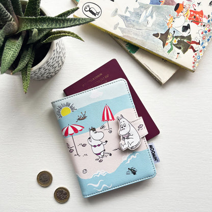 Moomin beach passport holder with a passport, coins and a plant