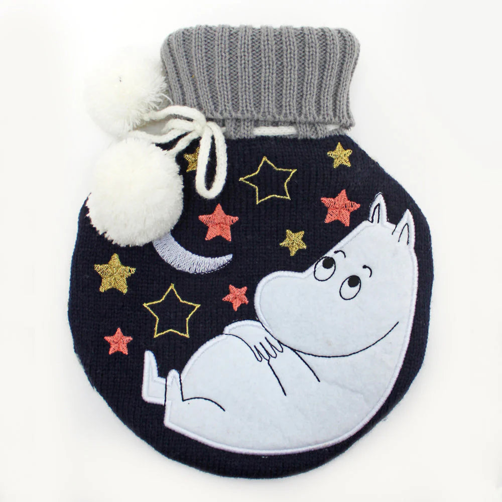 Round navy knitted hot water bottle with Moomintroll asleep on a crescent moon among stars