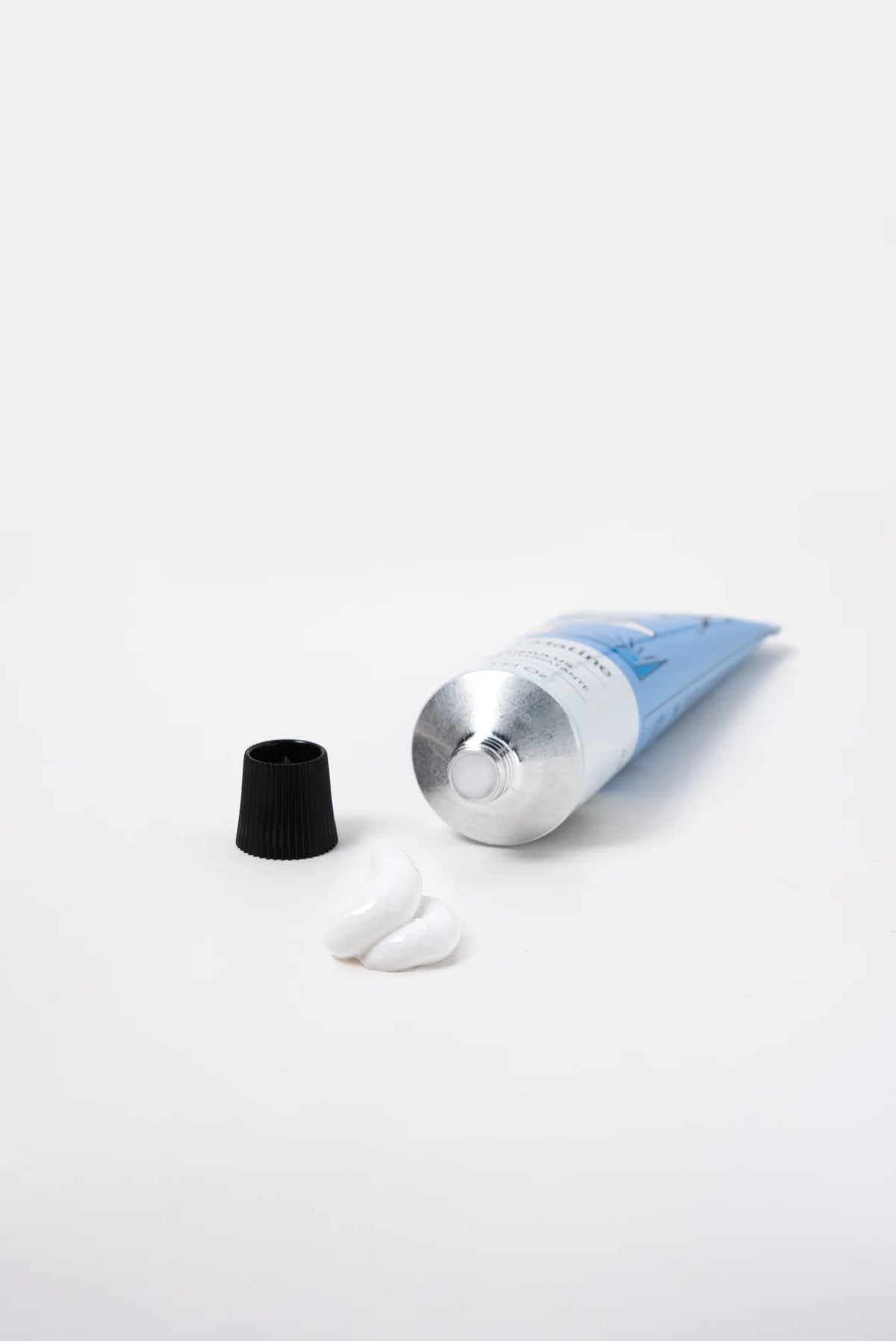 Hand cream tube with its cap off and a dab of cream