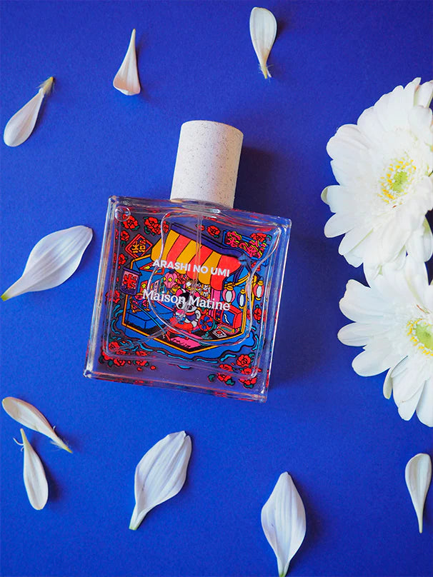 Arashi no Umi perfume among white flowers and petals on blue