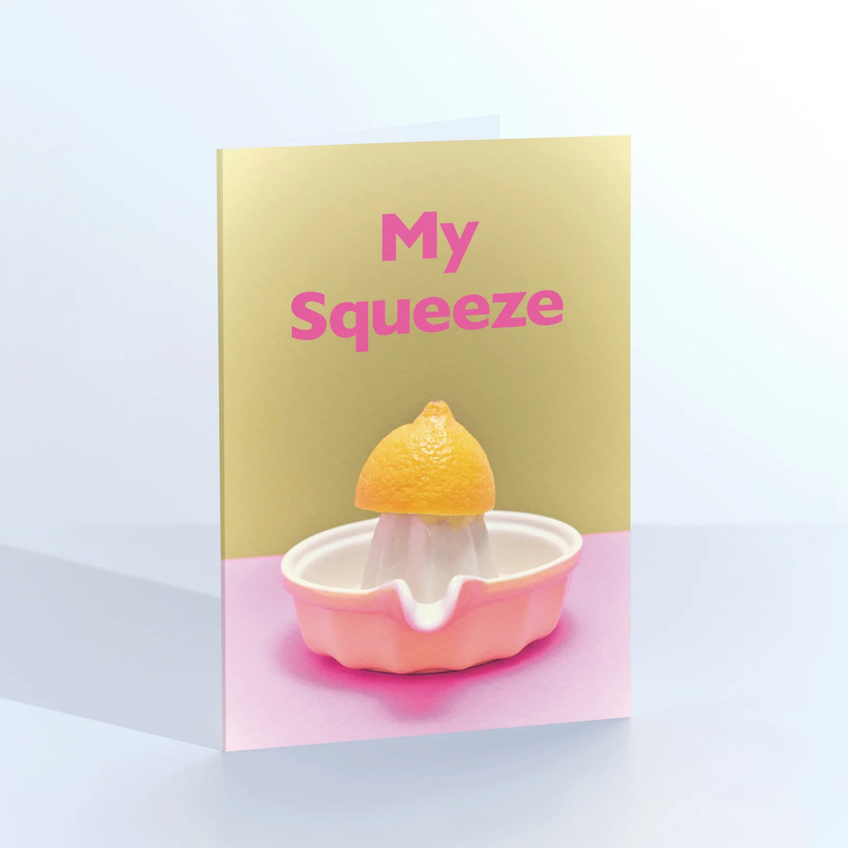 Ornament card: half a lemon on a pink vintage juicer, with 'My squeeze' on yellow