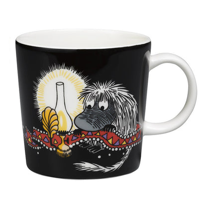 Moomin Ancestor mug: the hairy Ancestor beside an oil lamp, on black