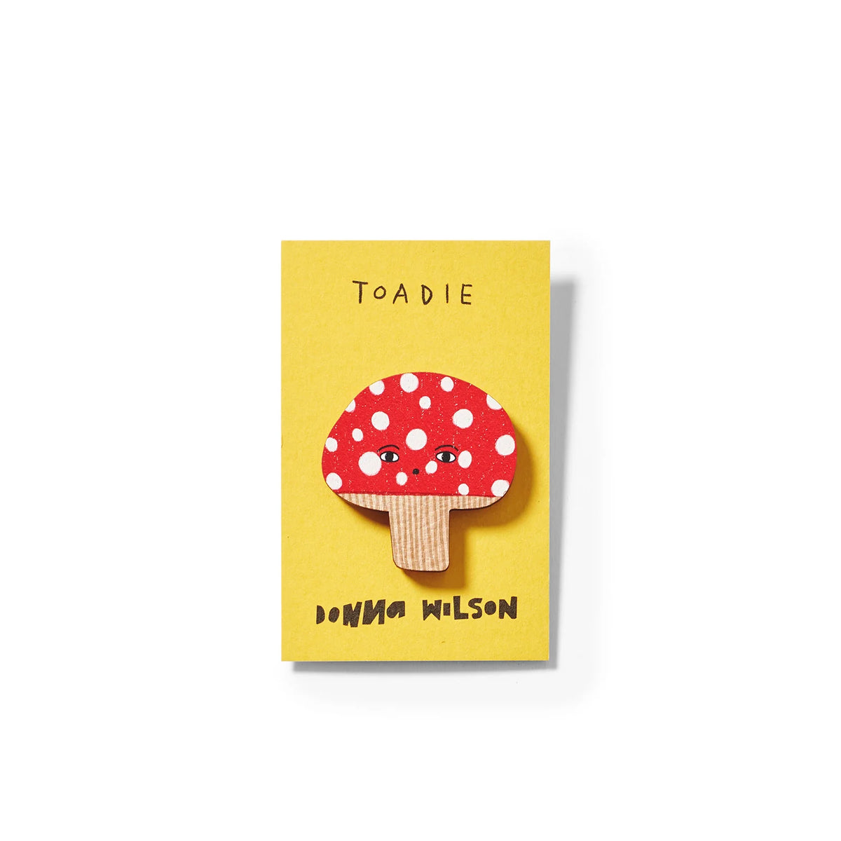 Red and white spotted toadstool pin badge on a yellow card: Toadie