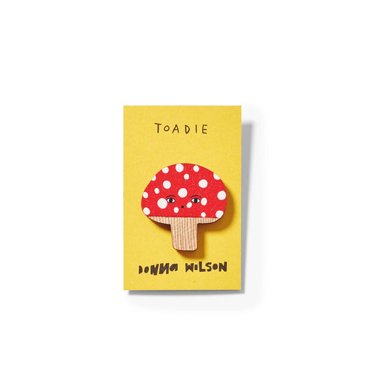 Red and white spotted toadstool pin badge on a yellow card: Toadie