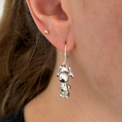Snoopy earring worn on an ear