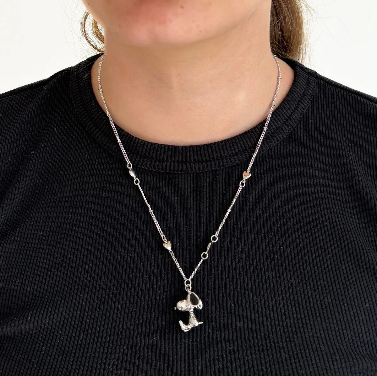 Peanuts 3D necklace worn over a black top