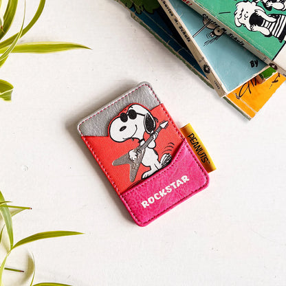 Rockstar card holder beside Peanuts books and a plant