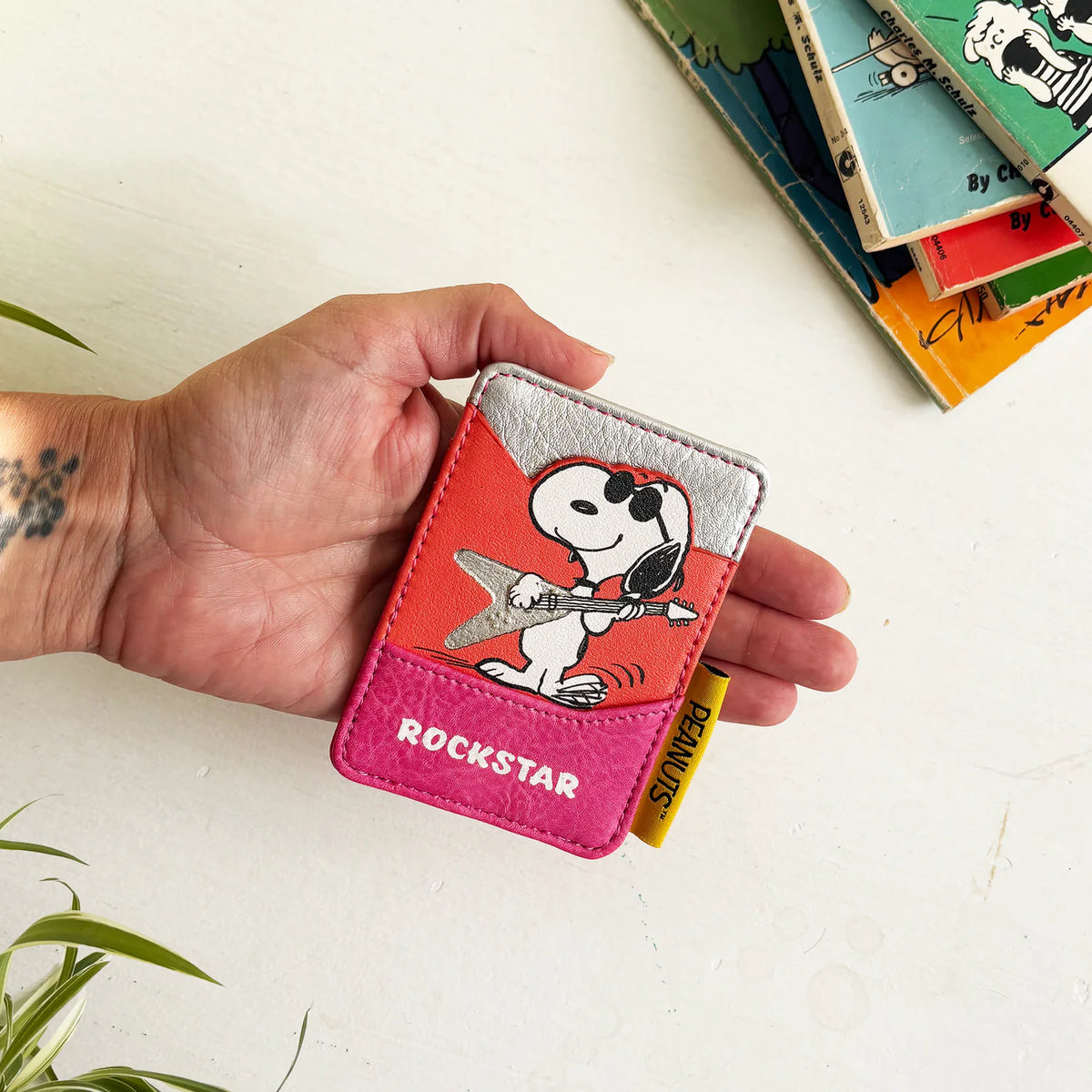 Hand holding the Peanuts Rockstar card holder