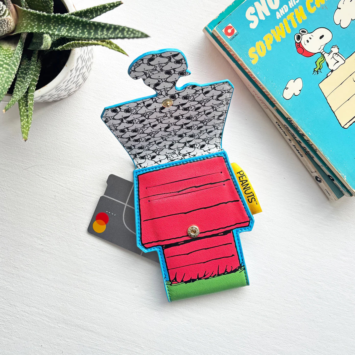 Doghouse card holder holding a card, beside a Snoopy book