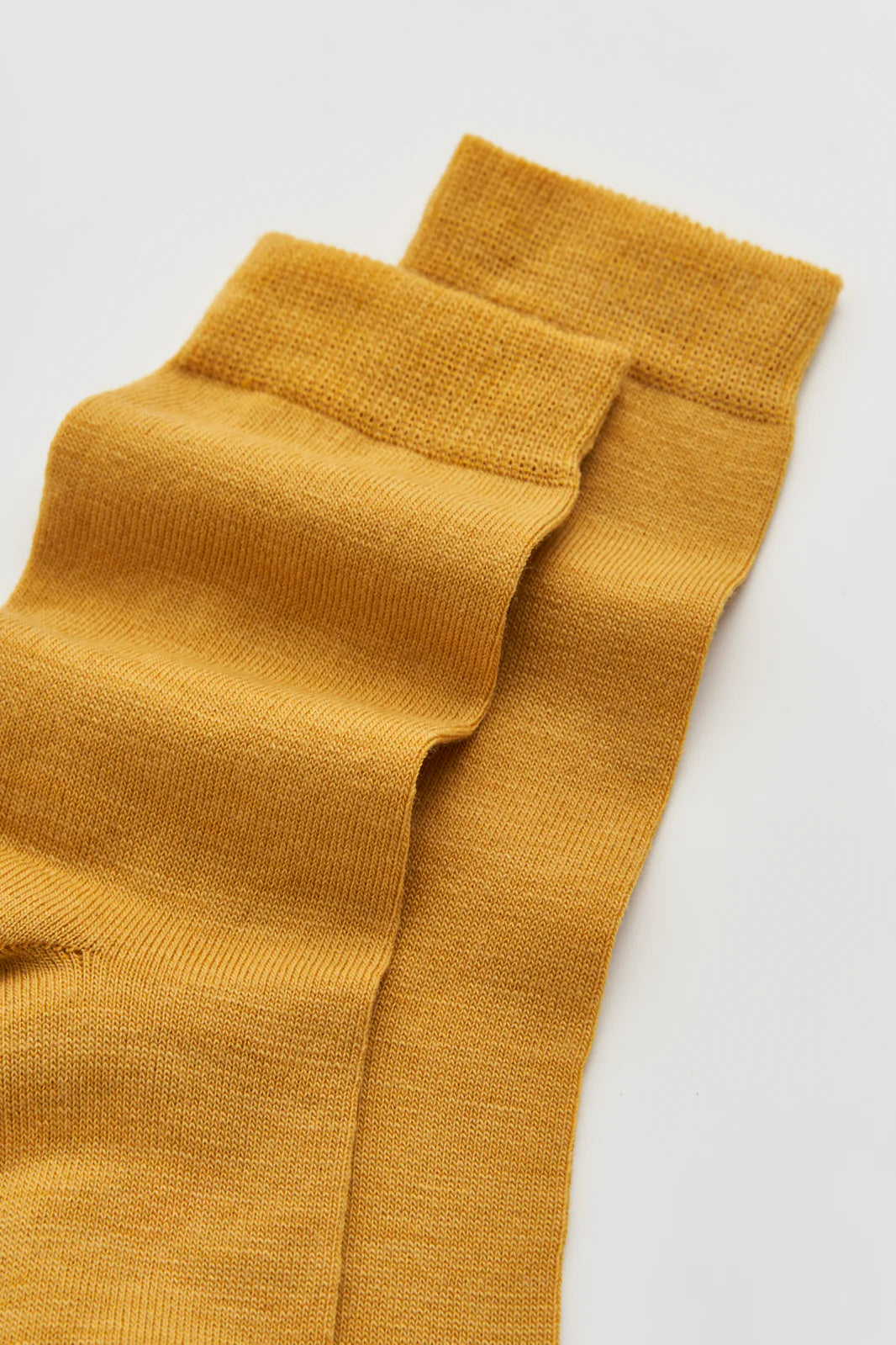 Close-up of the smooth golden yellow merino knit