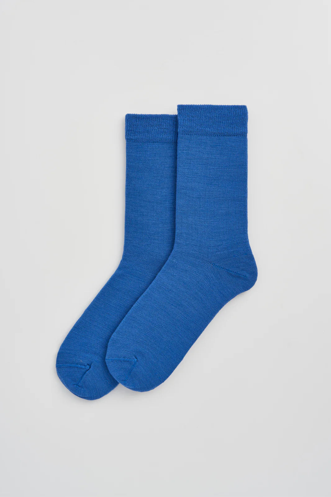 Pair of strong blue calf-length merino socks laid flat