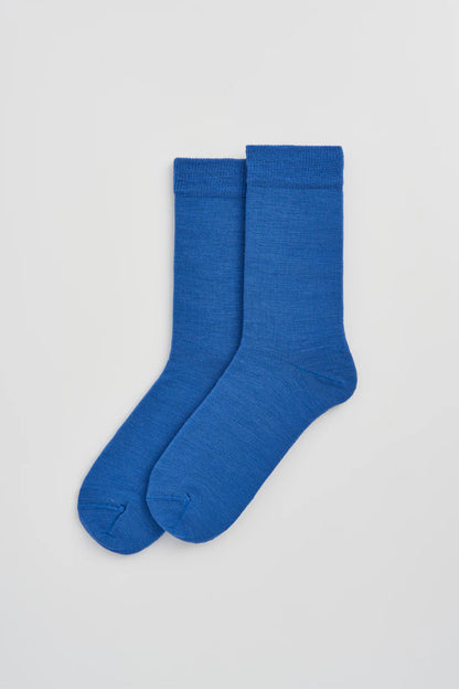 Pair of strong blue calf-length merino socks laid flat