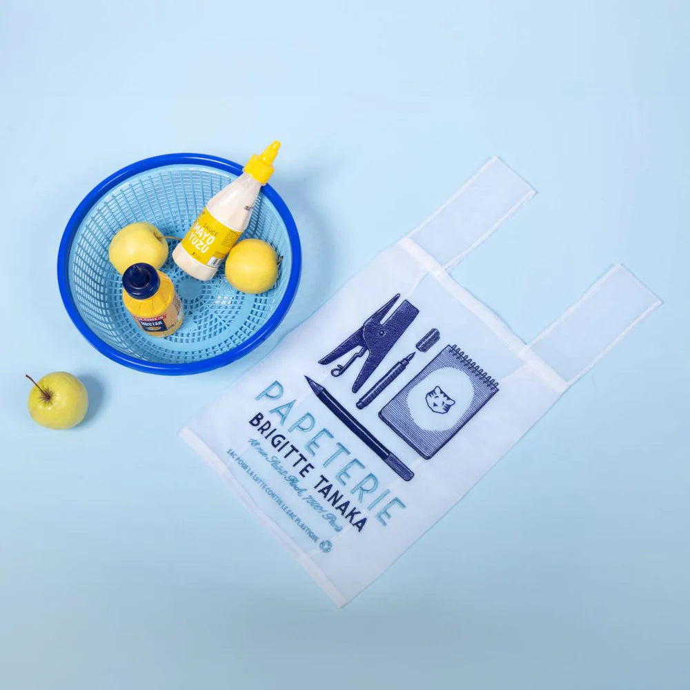 Papeterie organza bag on blue beside a basket of lemons