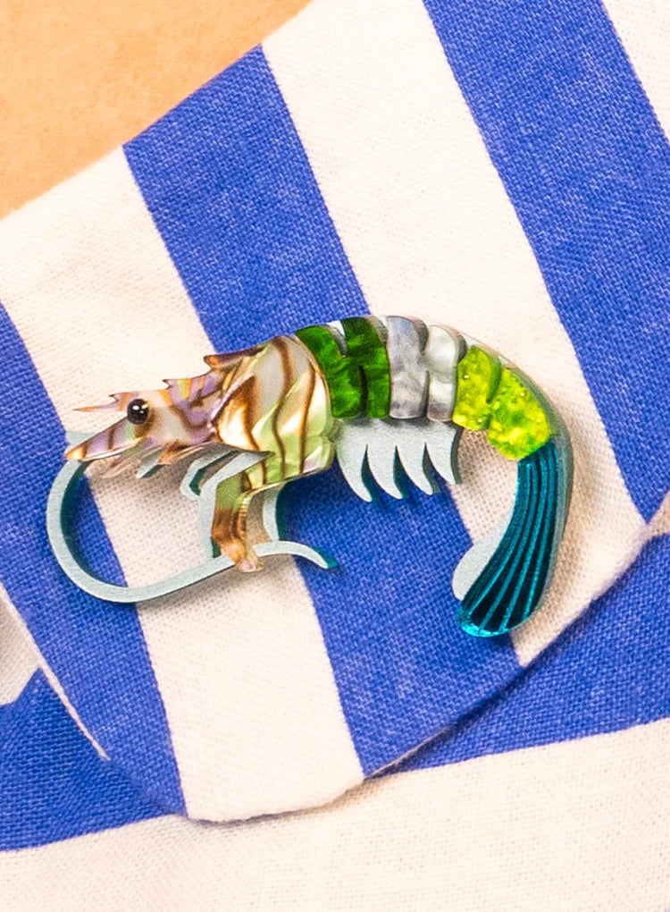 Prawn brooch on a blue and white striped cloth