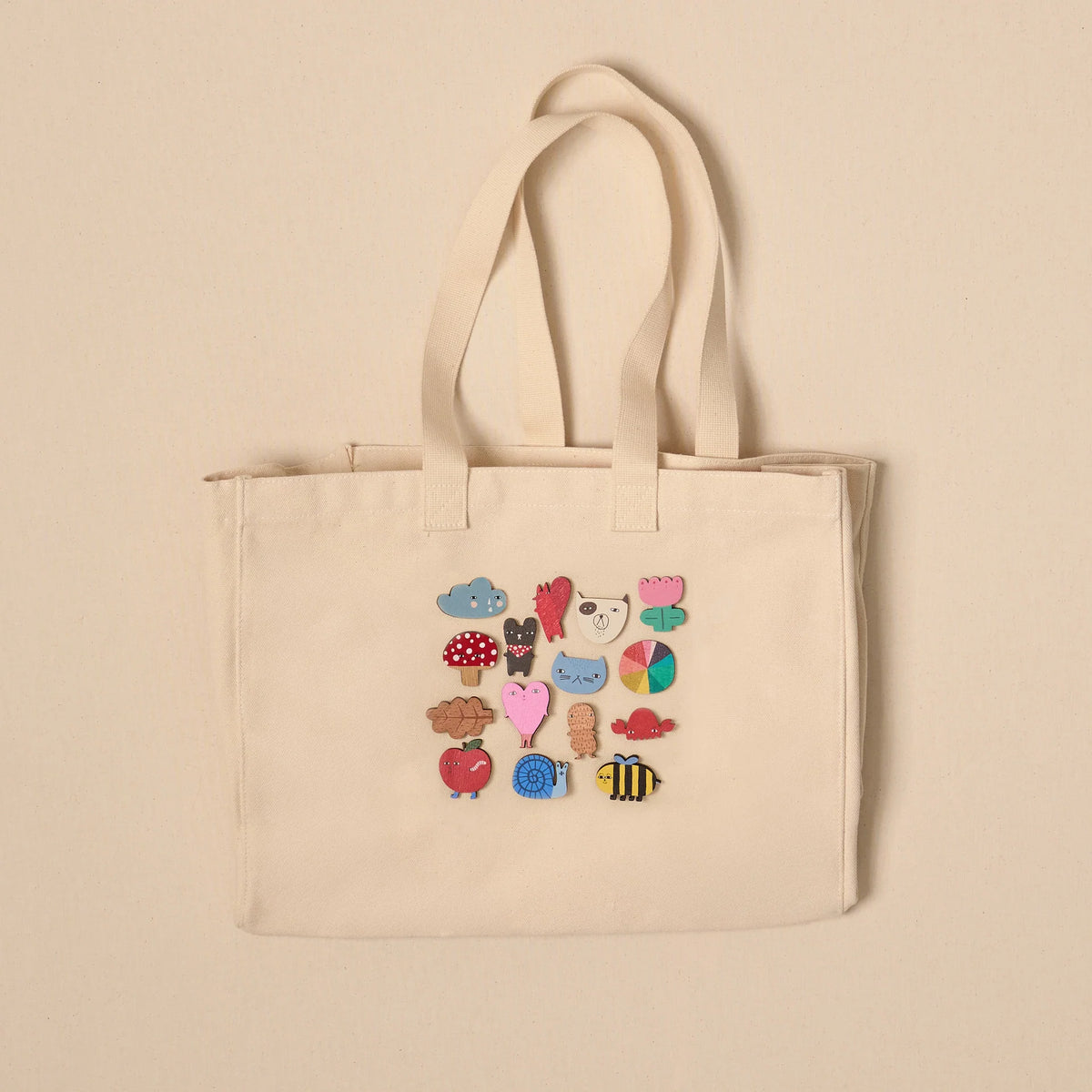 Canvas tote bag decorated with Donna Wilson pin badges