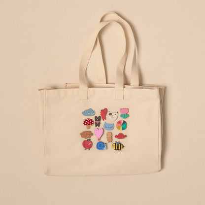 Canvas tote bag decorated with Donna Wilson pin badges