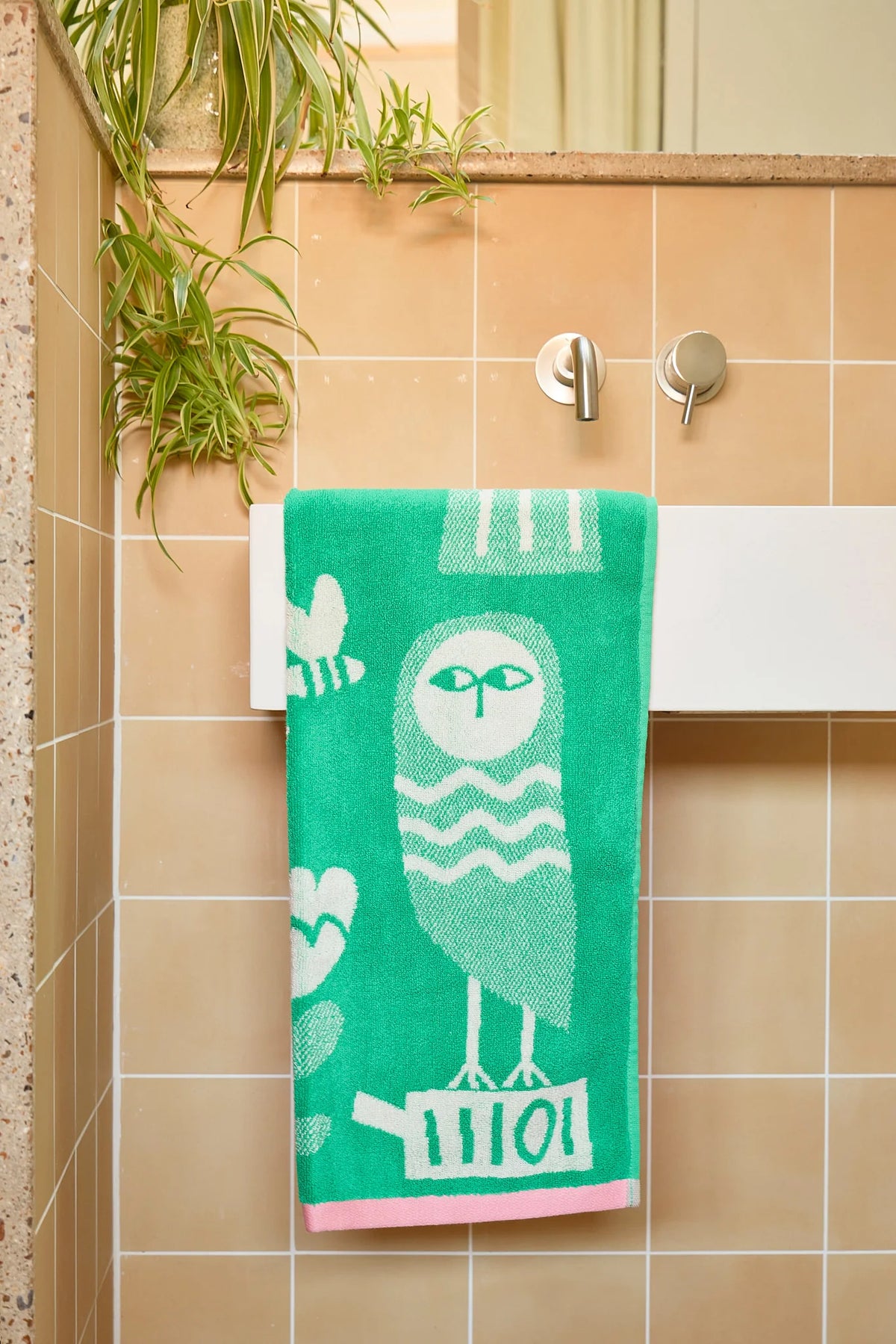 Birds and Bees hand towel hanging on a rail in a tiled bathroom