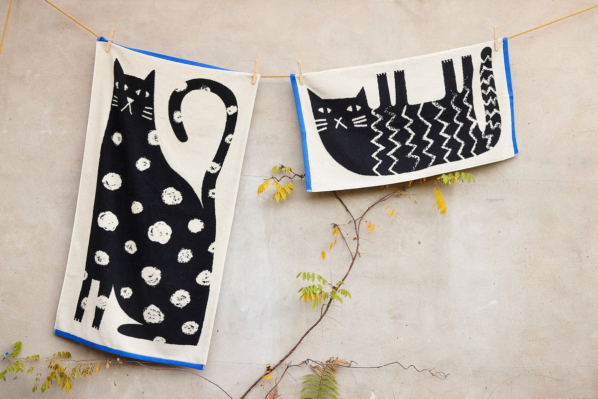 Two Donna Wilson cat towels on a washing line