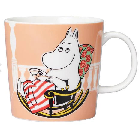 Moominmamma Marmalade mug: Moominmamma in a rocking chair with a cup of tea, on peach