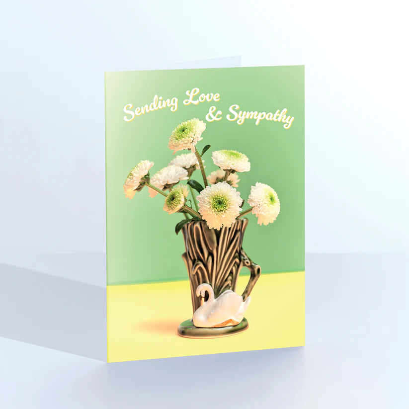 Ornament card: white flowers in a swan vase, with 'Sending love & sympathy' on green