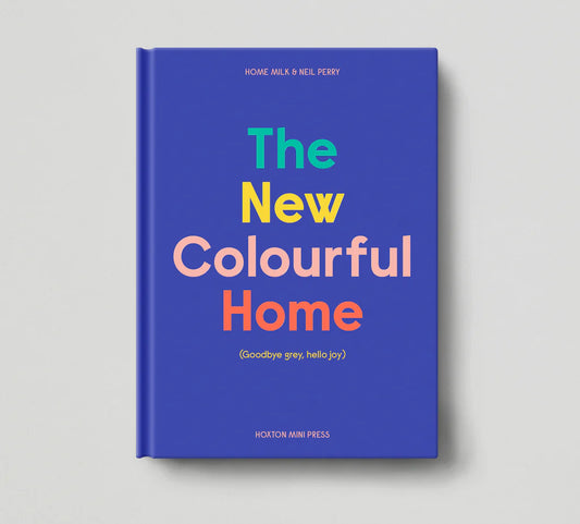 The New Colourful Home book with a blue cover and multicoloured lettering: Goodbye grey, hello joy