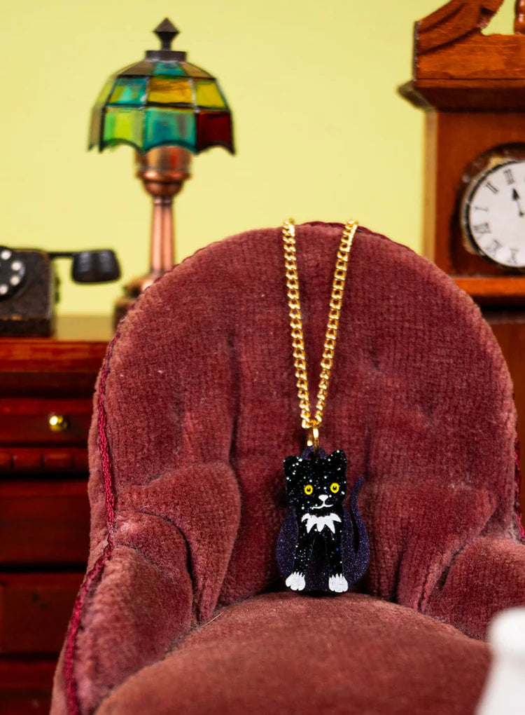 Toy cat pendant on a red velvet armchair