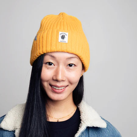 Woman wearing the yellow Stinky beanie