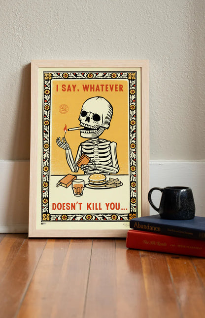 Whatever Doesn't Kill You print leaning on a wall by books and a mug
