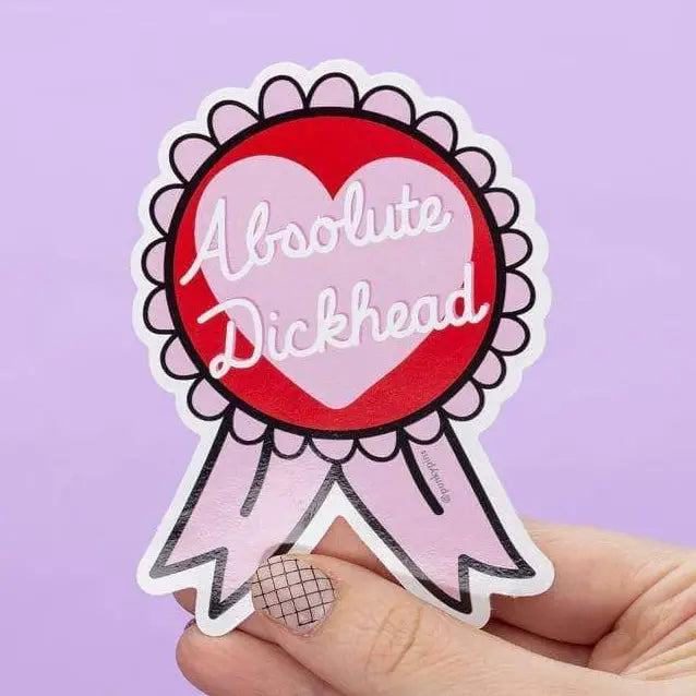 Punky Pins rosette sticker reading 'Absolute dickhead', held in a hand