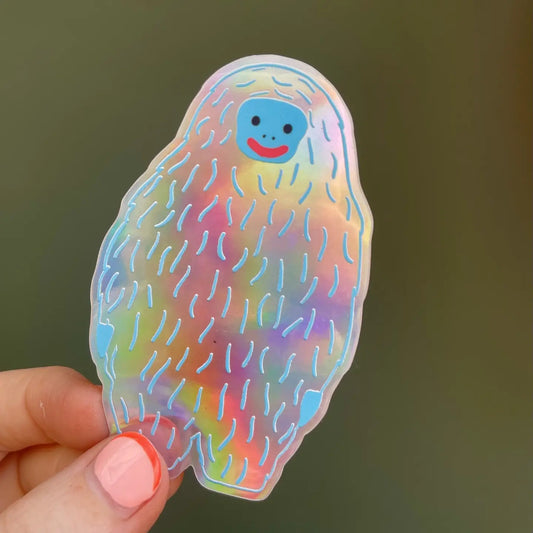Naomi Wilkinson holographic yeti sticker, held in a hand