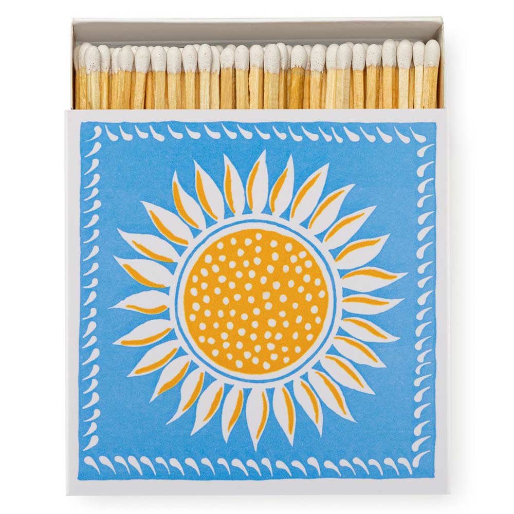Square box of luxury matches with a yellow sun on a blue background