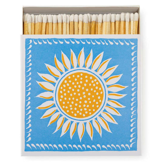 Square box of luxury matches with a yellow sun on a blue background
