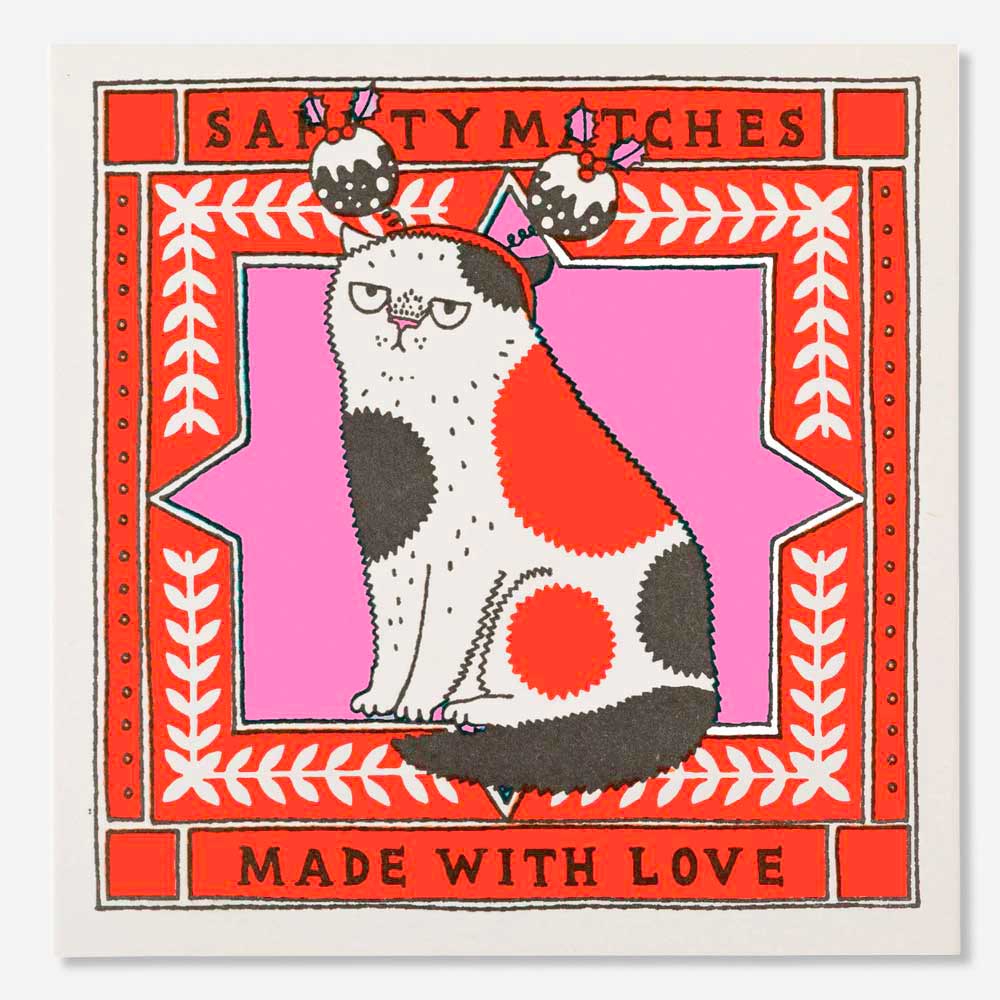Square matchbox with a grumpy spotted cat wearing Christmas puddings on its head: Santy Matches, made with love
