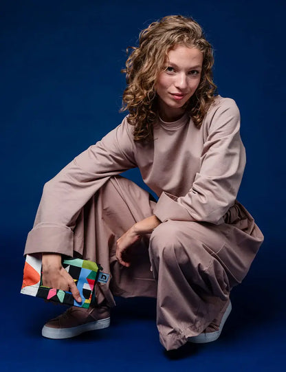 Woman crouching with the Playground crossbody bag