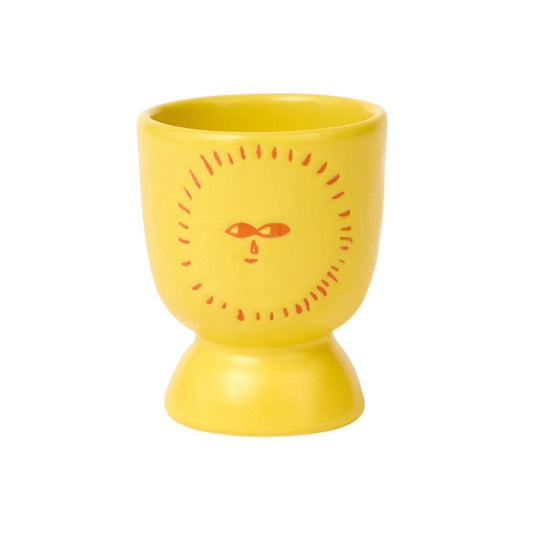 Yellow ceramic egg cup with an orange sun face