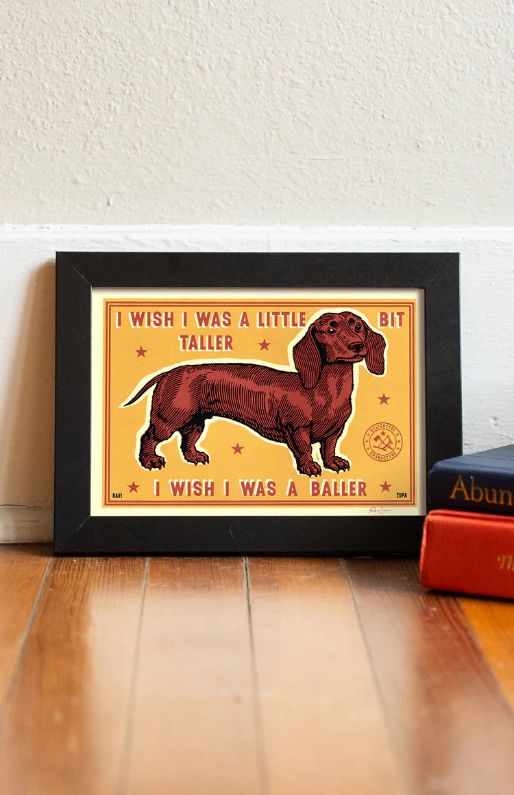 I Wish I Was a Baller print in a frame on a wooden floor