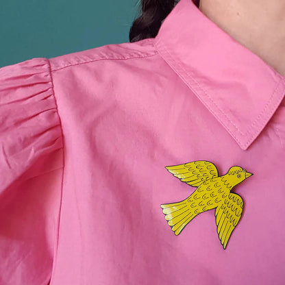 Yellow bird badge on a pink shirt
