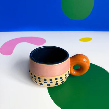 Chunky handle cup on a colourful painted background