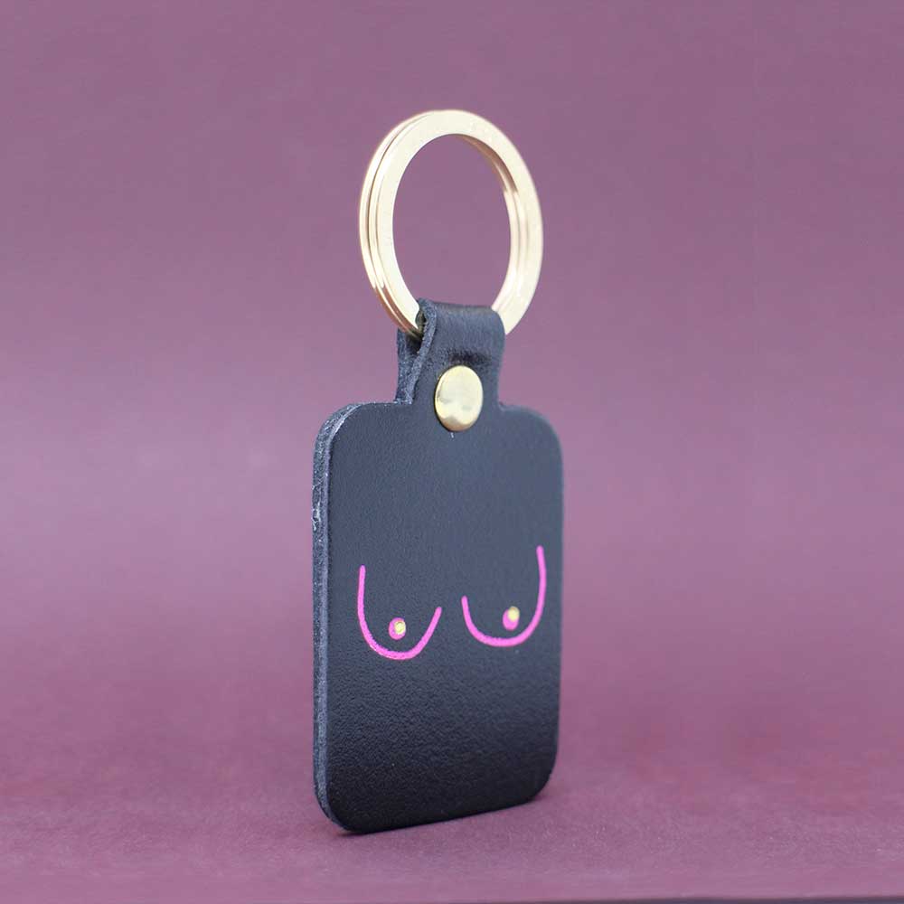 Ark black leather key fob with a pink line drawing of boobs and a gold ring