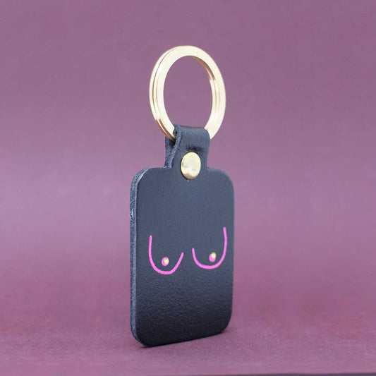 Ark black leather key fob with a pink line drawing of boobs and a gold ring